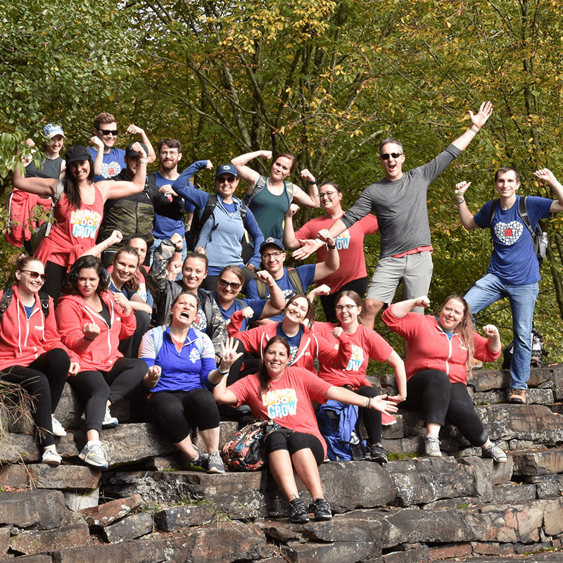 Group Photo of Team Sitting on Rocks Making Muscles, Silly Faces and Posing